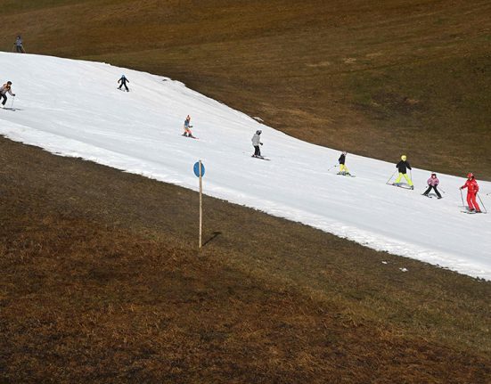 Skiers gliding down an artificial snow slope