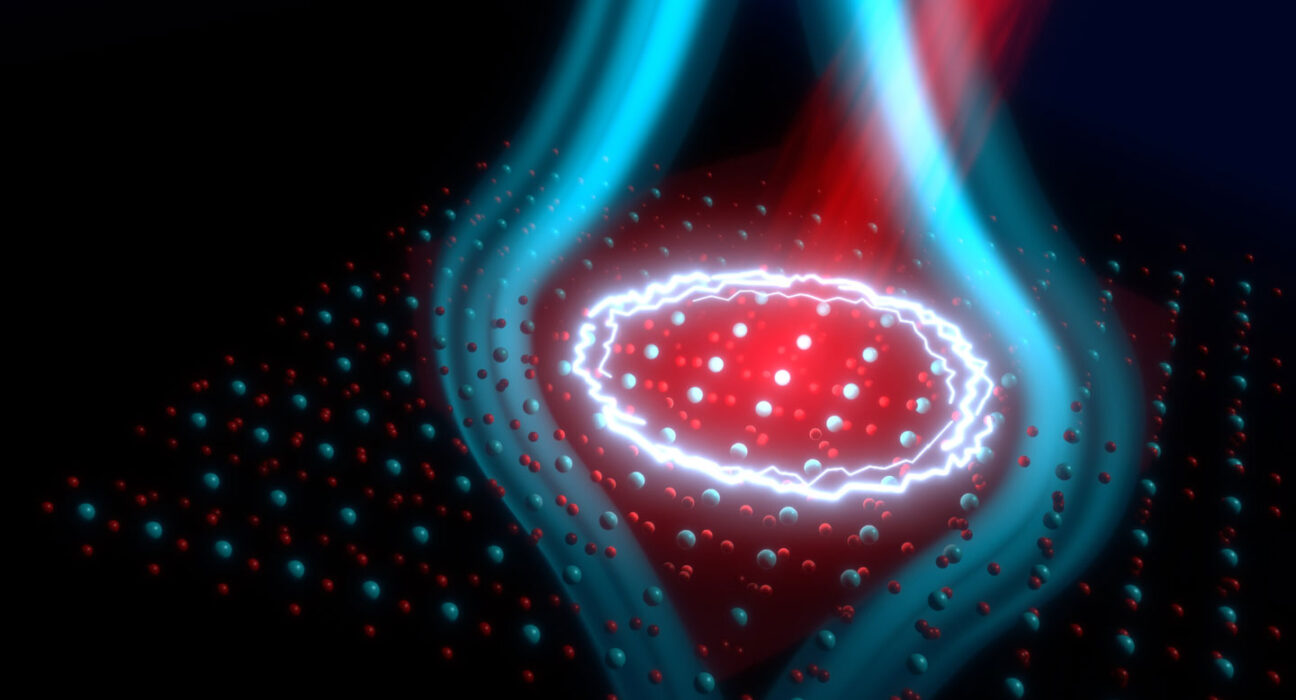 An illustration shows a grid of atoms being hit with a red beam of laser light. Blue lines indicating a magnetic field emanate from the lit-up region.