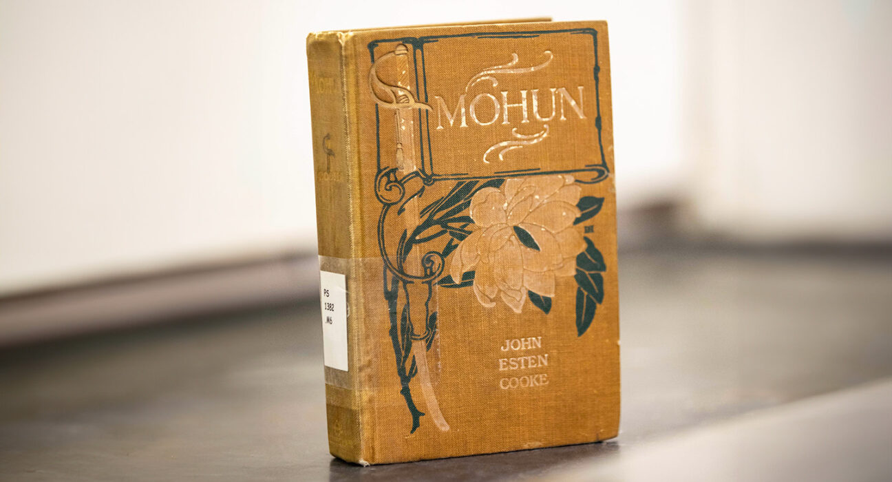 A Victorian-era book titled Mohun is propped up to show it