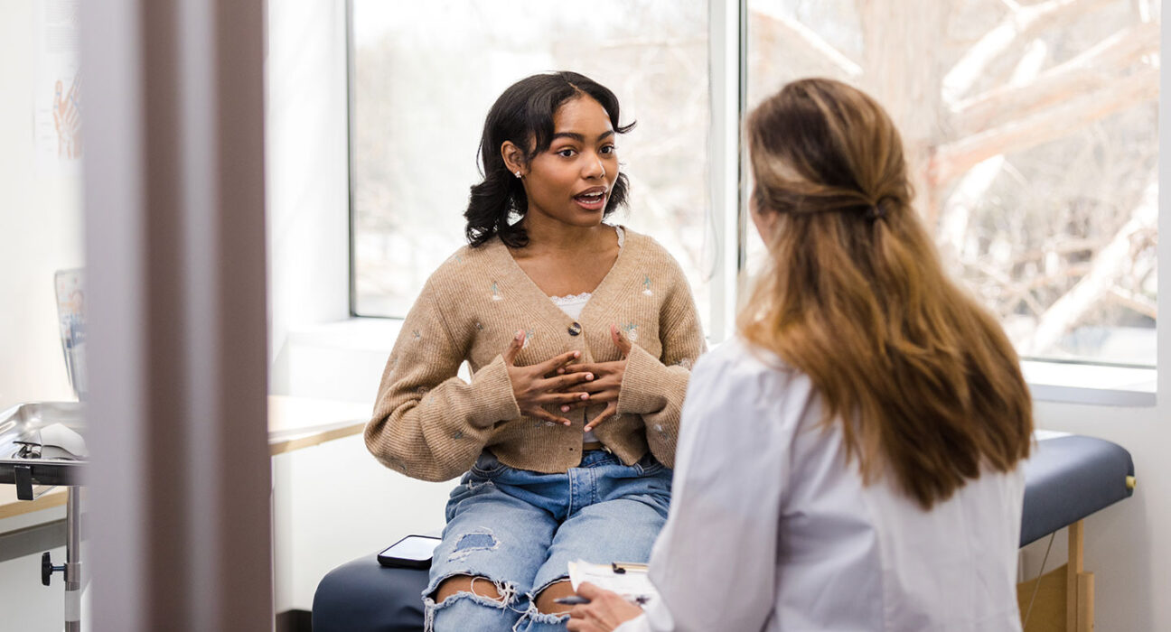 a teen girl speaking with a doctor in a clinic