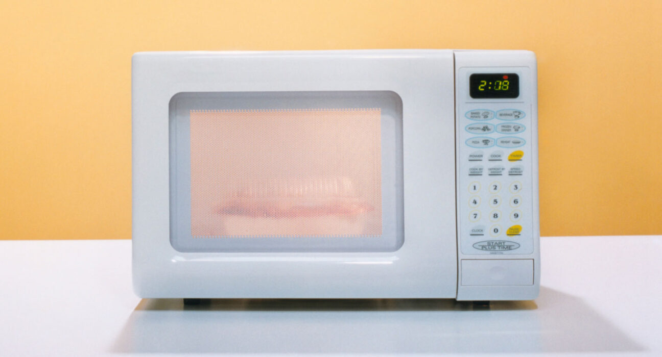 a photo of a microwave oven against an orange backdrop