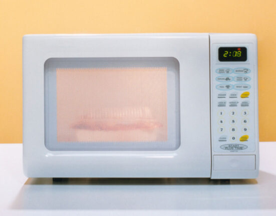 a photo of a microwave oven against an orange backdrop