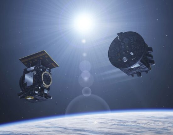 Two satellites floating above the Earth, with the sun in the background.