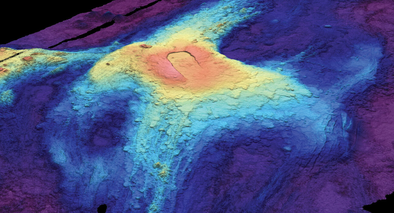 A heat map image of the ocean floor shows bloblike circles of red, yellow, and blues fading out from the volcano