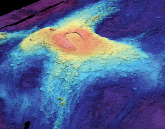 A heat map image of the ocean floor shows bloblike circles of red, yellow, and blues fading out from the volcano