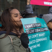 A crowd of young people holding signs, including one saying "I have a right to live tobacco free"