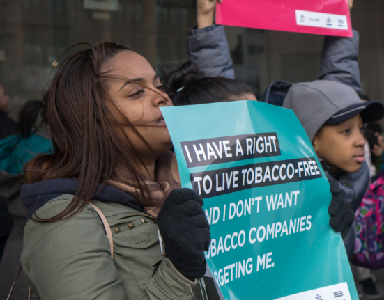 A crowd of young people holding signs, including one saying "I have a right to live tobacco free"